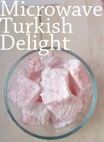 a glass bowl filled with pink marshmallows on top of a wooden table