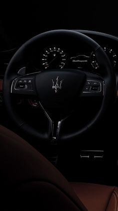 the interior of a car with dashboard lights and steering wheel controls, along with leather seats