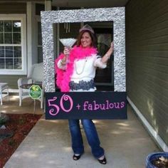 a woman in pink and white holding up a sign that says 50 fabulous with an image of her on it