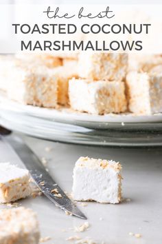 the best toasted coconut marshmallows on a platter with a knife