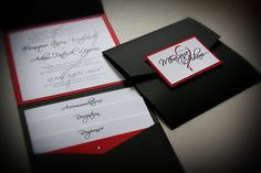 two black and white envelopes with red trim on the inside, one has a note attached to it