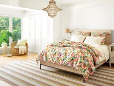 a bed sitting in a bedroom next to a window with lots of plants on it