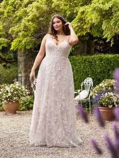 a woman in a wedding dress posing for the camera with her hand on her head