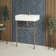 a white sink sitting under a bathroom mirror next to a green towel on a rack