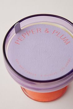 an orange and purple container with the words pepper & plum on it's lid