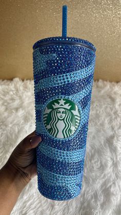 the starbucks cup is decorated with blue and white glitters