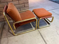 an orange chair and ottoman sitting on the sidewalk