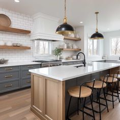 a large kitchen with an island and lots of stools in the middle of it