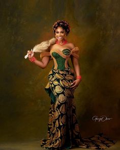 an african woman in a green and gold dress