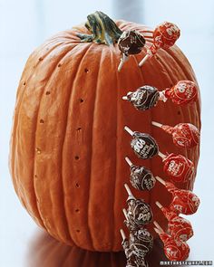 an orange pumpkin with chocolate candies on it's side and the words pumpkin lollipop holder