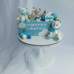 there is a blue and white cake with teddy bears on the top that says i love you in russian