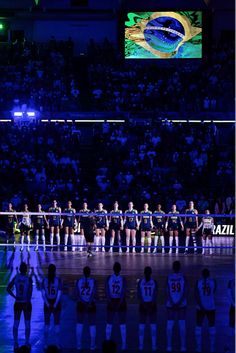 a group of people standing on top of a basketball court