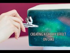 a person holding a piece of cake with the words creating a galaxy effect on it