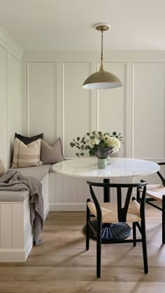 a dining room with white walls and wood flooring