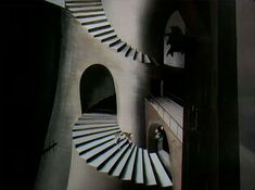 a man standing on top of a set of stairs next to a spiral stair case