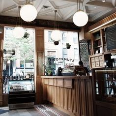 the inside of a coffee shop with lots of lights hanging from it's ceiling