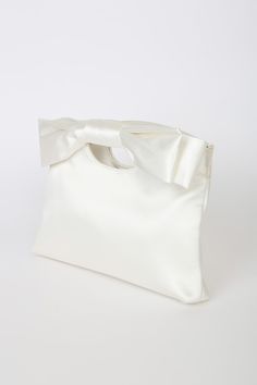 Complete your big day look with the Lulus Total Romantic White Satin Bow Clutch! Sleek woven satin shapes darling clutch that has a cutout handle at the top and a decorative bow at the front. Magnetic closure opens to a lined interior with a single sidewall pocket. Detachable silver chain strap. Fully lined. Bag measures 10. 5" wide, 7. 5" tall, and 1. 75" deep (relaxed). Detachable 46" strap. Strap has a drop of 22â€. Shell: 100% Polyester. Lining: 100% Polyester. Imported. Lulus | Total Roman Chic Party Bag With Ribbon Detail, Chic Party Bag With Ribbon, Elegant Bags With Decorative Bow, Elegant Wedding Bags With Bow Detail, Elegant Wedding Bags With Bow, Elegant Clutch Bag With Bow, Elegant Bags With Bow For Events, Chic Wedding Bags With Bow Detail, Chic Wedding Bag With Bow