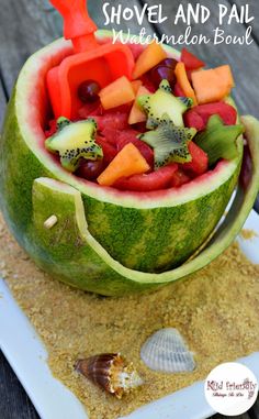 a watermelon bowl filled with fruit and vegetables