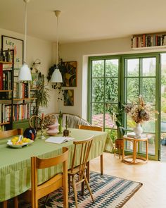 a dining room filled with lots of furniture and bookshelves next to a window