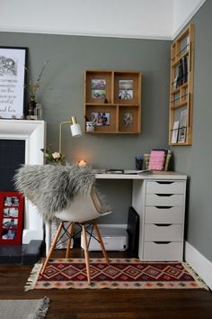 a room with a desk, chair and shelves on the wall