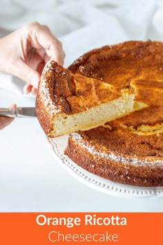 someone cutting into a cake with orange ricotta cheesecake on the top and bottom