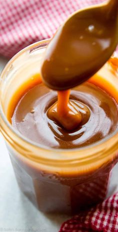 a spoon full of caramel sauce being drizzled on top of it