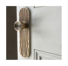 a door handle on the side of a white door with a gold ring in it