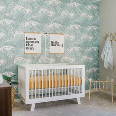 a baby's room decorated in green and white with two pictures on the wall