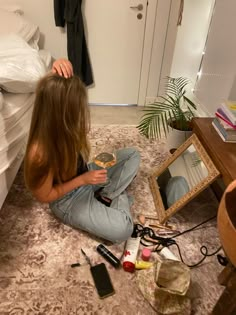 a woman sitting on the floor in front of a mirror