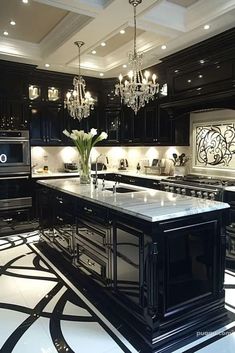 a black and white kitchen with chandelier hanging from the ceiling, marble flooring