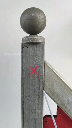 a metal pole with a ball on top and a stick sticking out of it's side