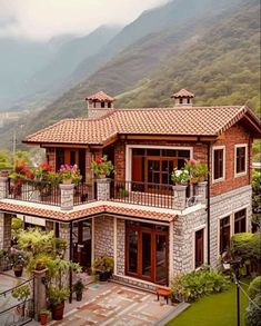 a house with flowers on the balconies in front of it and mountains in the background