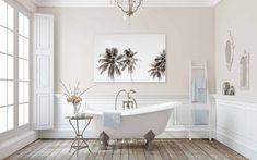 a white bath tub sitting in a bathroom under a chandelier next to a window