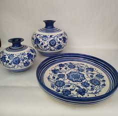 three blue and white vases sitting next to each other