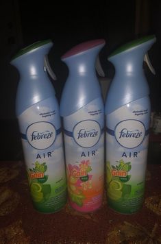 three bottles of air freshener sitting on a table