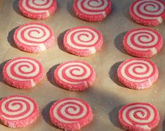 some red and white cookies are on a baking sheet