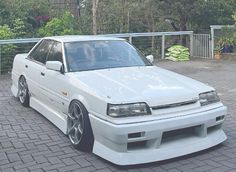 a white car parked on top of a brick road