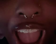 an open mouth with water drops on it and one person's face in the background