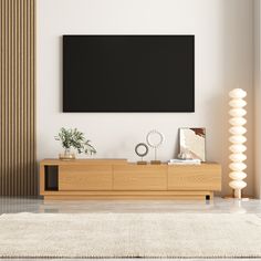 a living room with a large flat screen tv mounted on the wall above a wooden entertainment center