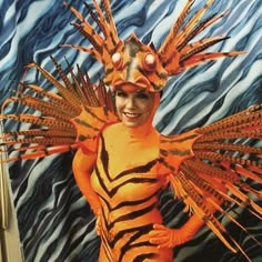 a woman dressed in orange and black costume