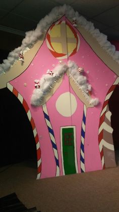 a pink house with candy canes and snow on the roof