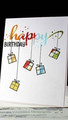 a birthday card with gift boxes hanging from strings