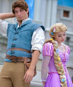 a man and woman dressed up as rappui and aurora from the disney movie