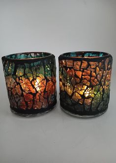 two stained glass candlesticks sitting next to each other