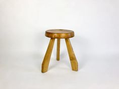 a small wooden stool sitting on top of a white floor