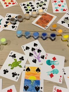 playing cards and paints laid out on a table