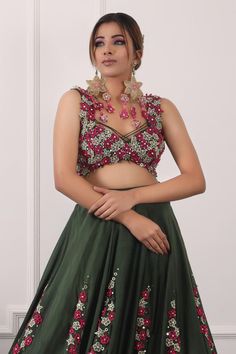 Dark green lehenga with placement floral embroidery. Paired with a padded blouse with all over floral bloom embroidery and dupatta with floral embroidery.
Components: 3
Pattern: Hand Embroidery
Type Of Work: Sequins, Floral
Neckline: Sweetheart Neck
Sleeve Type: Sleeveless
Fabric: Blouse and Dupatta: Net, Lehenga: Satin
Color: Green
Other Details: 
Attached inner lining
Lehenga:
Length: 45 inches
Blouse:
Length: 14
Padded
Crystal embellished hem
Floral tasselled back tie-up detailing
Dupatta:
Cr Sleeveless Hand Embellished Lehenga For Wedding, Sleeveless Organza Sharara For Party, Glamorous Hand Embellished Sleeveless Lehenga, Glamorous Sleeveless Hand Embellished Lehenga, Green Georgette Top For Wedding, Glamorous Sleeveless Lehenga For Festive Occasions, Hand Embellished Sleeveless Party Choli, Sleeveless Organza Party Sets, Sleeveless Sets With Floral Embroidery For Party