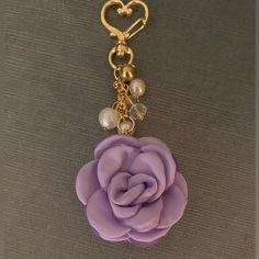 a close up of a key chain with a flower and heart charm attached to it