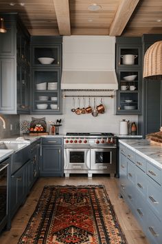 a kitchen with blue cabinets and an area rug on the floor in front of the stove