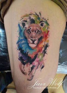 a watercolor lion tattoo on the back of a woman's upper half - arm